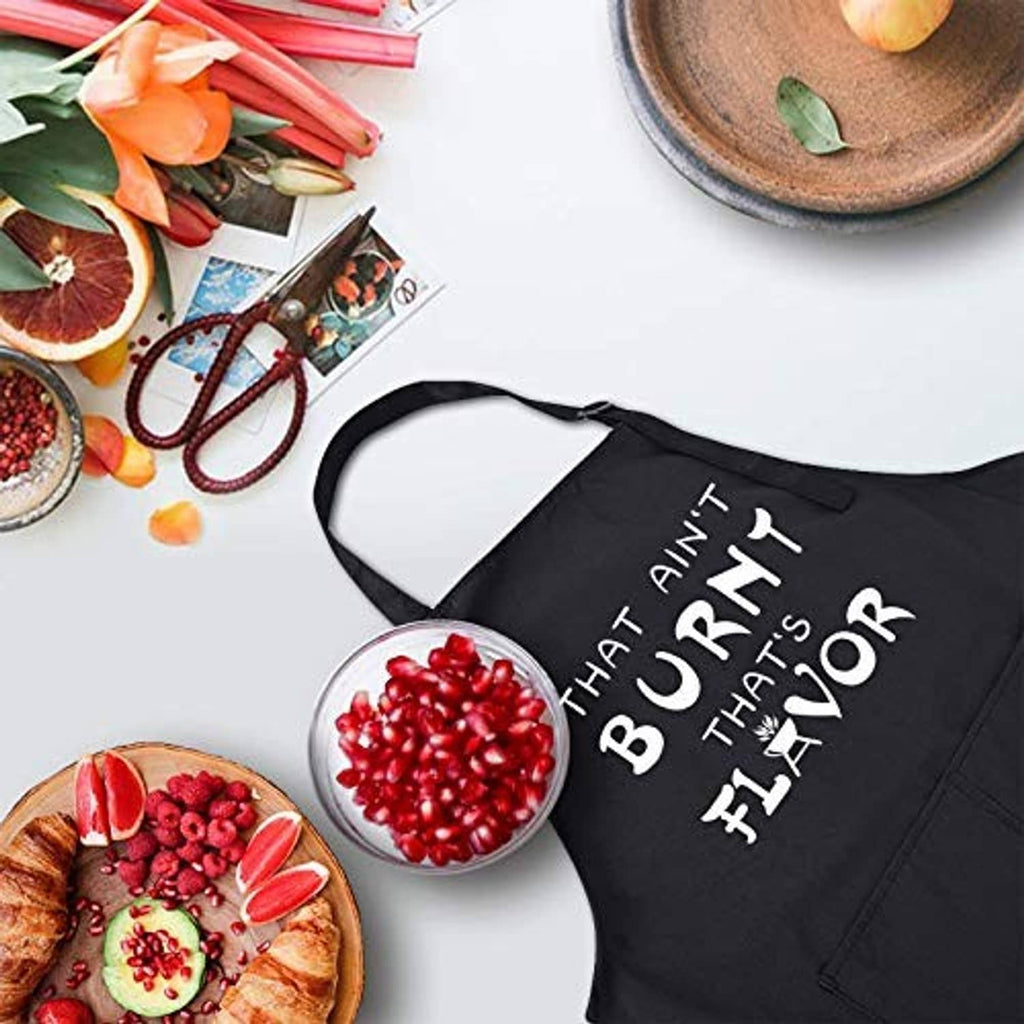 Black chef apron with “That Ain’t Burnt That’s Flavor” text on chest.