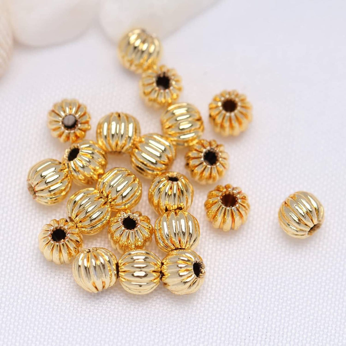 Cluster of gold-tone corrugated round beads with black center dots