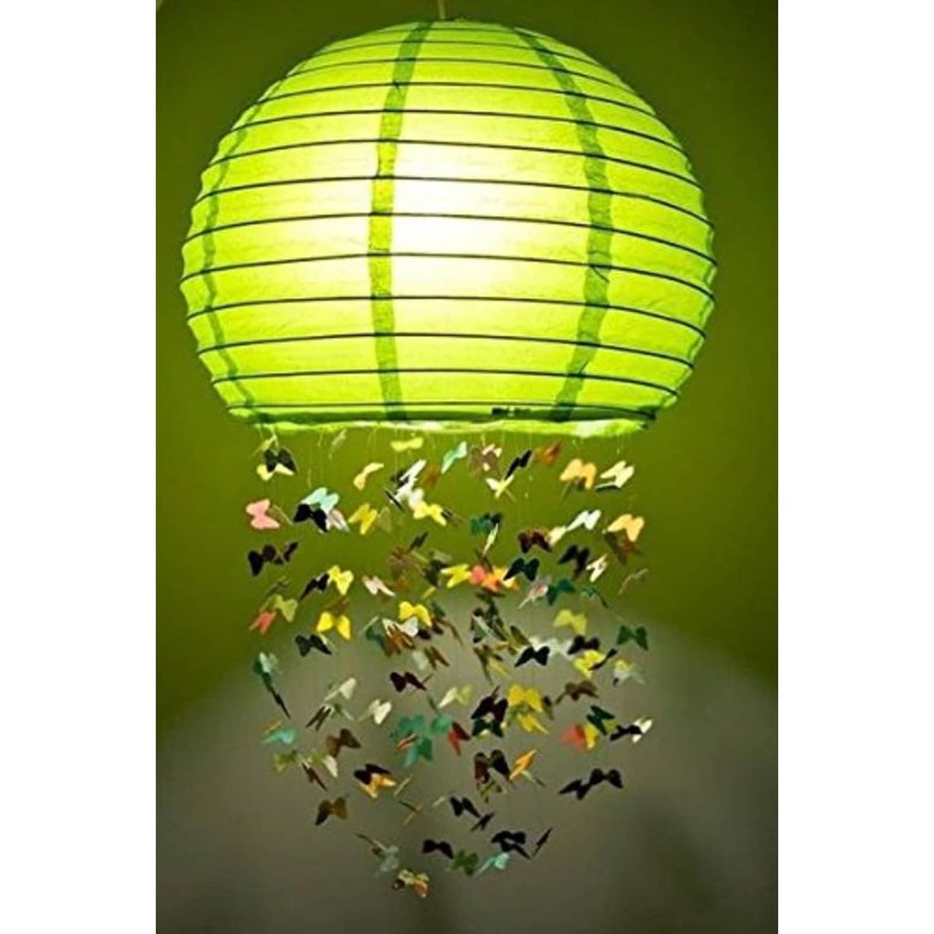White round paper lantern floating above multicolor butterfly decoration in outdoor scene
