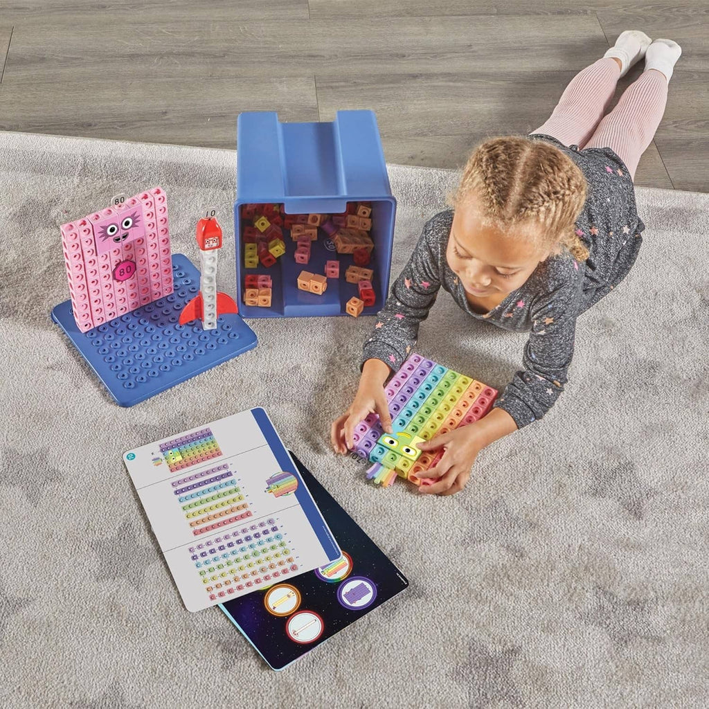 Child playing with multicolor Numberblocks cube boards, plus storage bin and activity cards