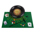 Roulette wheel set with cards, poker chips, and ball rake on green felt mat