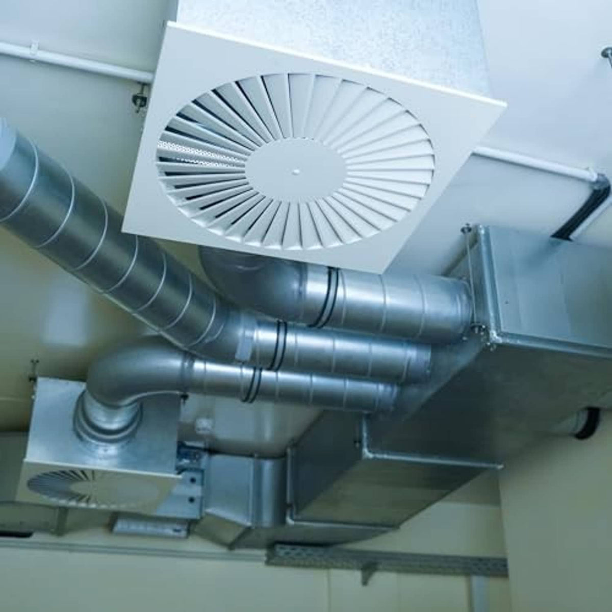 Rubber-lined split pipe hangers supporting a galvanized duct pipe run