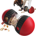 Red and black treat-dispensing puzzle slow feeder toy with clear center, filled with kibble