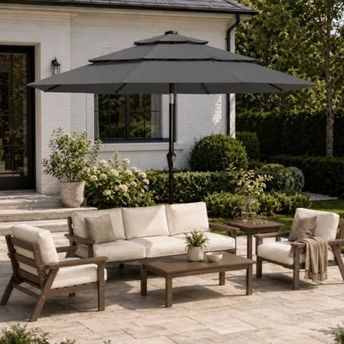 Grey 3-tier patio umbrella over outdoor seating, vented canopy