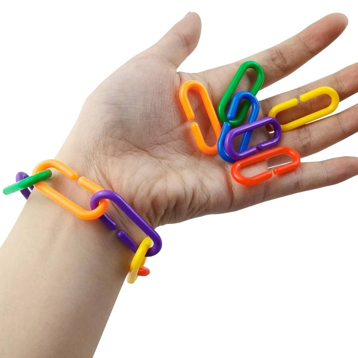 Multicolored plastic C-clips held in a hand, small U-shaped fasteners