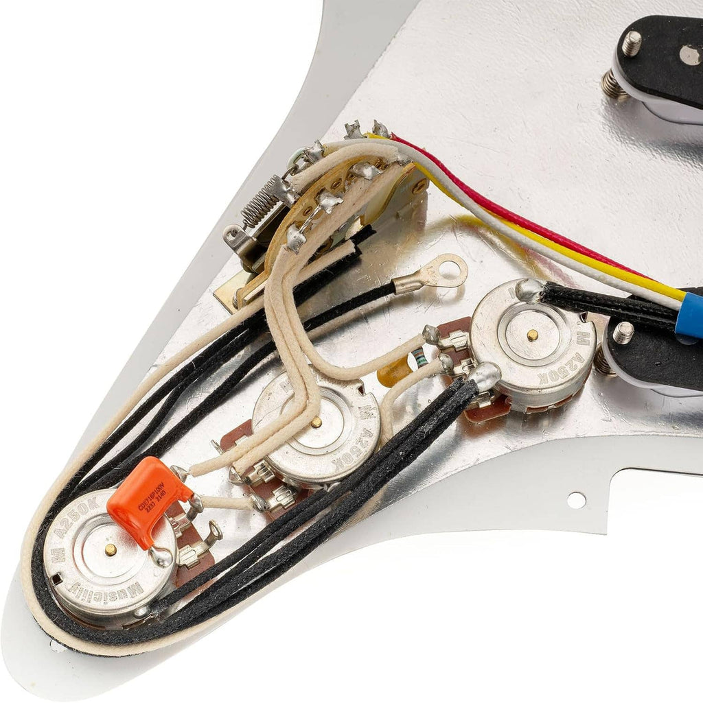 Close-up of pre-wired components and cables on white guitar pickguard underside