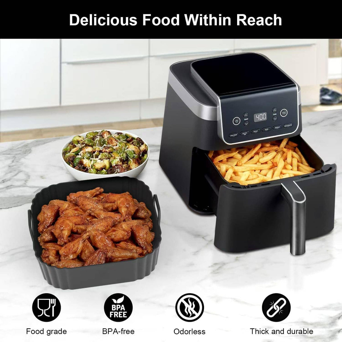 Black square silicone air fryer liner with fries and wings in the basket