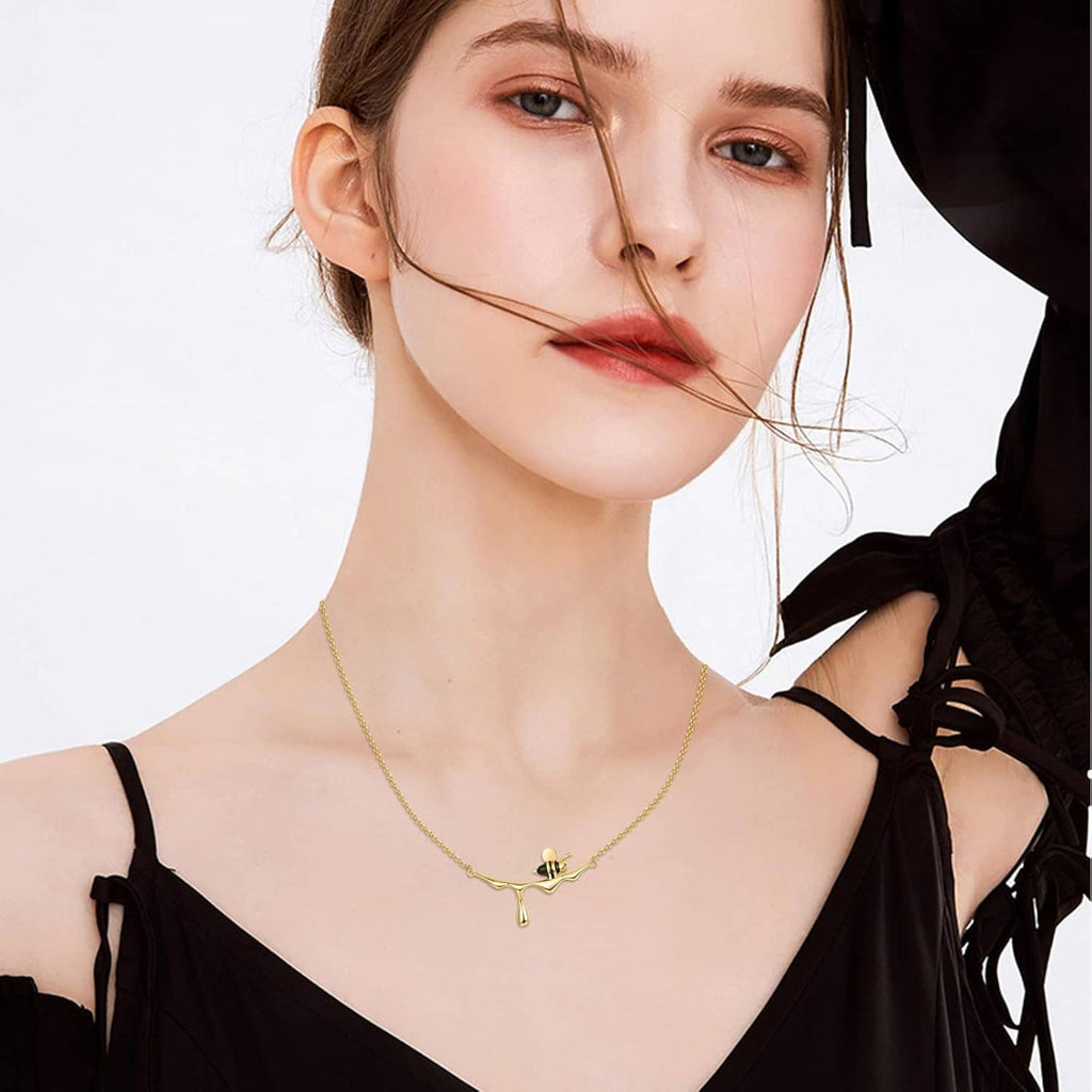 Gold-tone bee pendant necklace on a woman’s neckline with thin chain