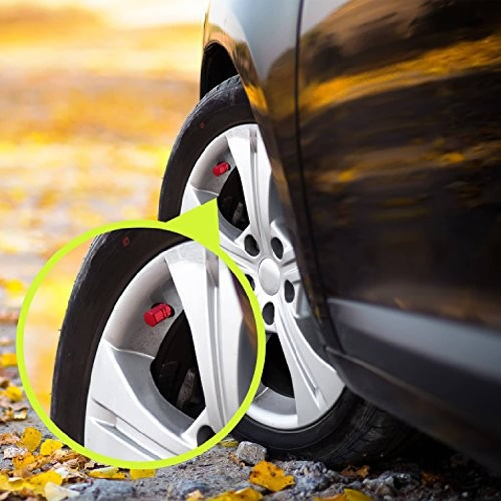 Red tire valve cap installed on a car wheel, highlighted near the tire valve