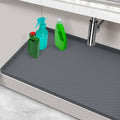 Gray under-sink silicone mat with hex-pattern surface and raised edges