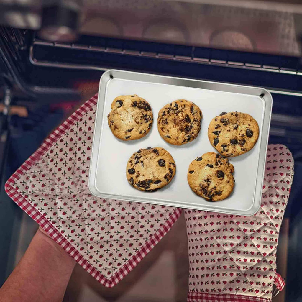 Rectangular stainless steel oven tray filled with chocolate chip cookies