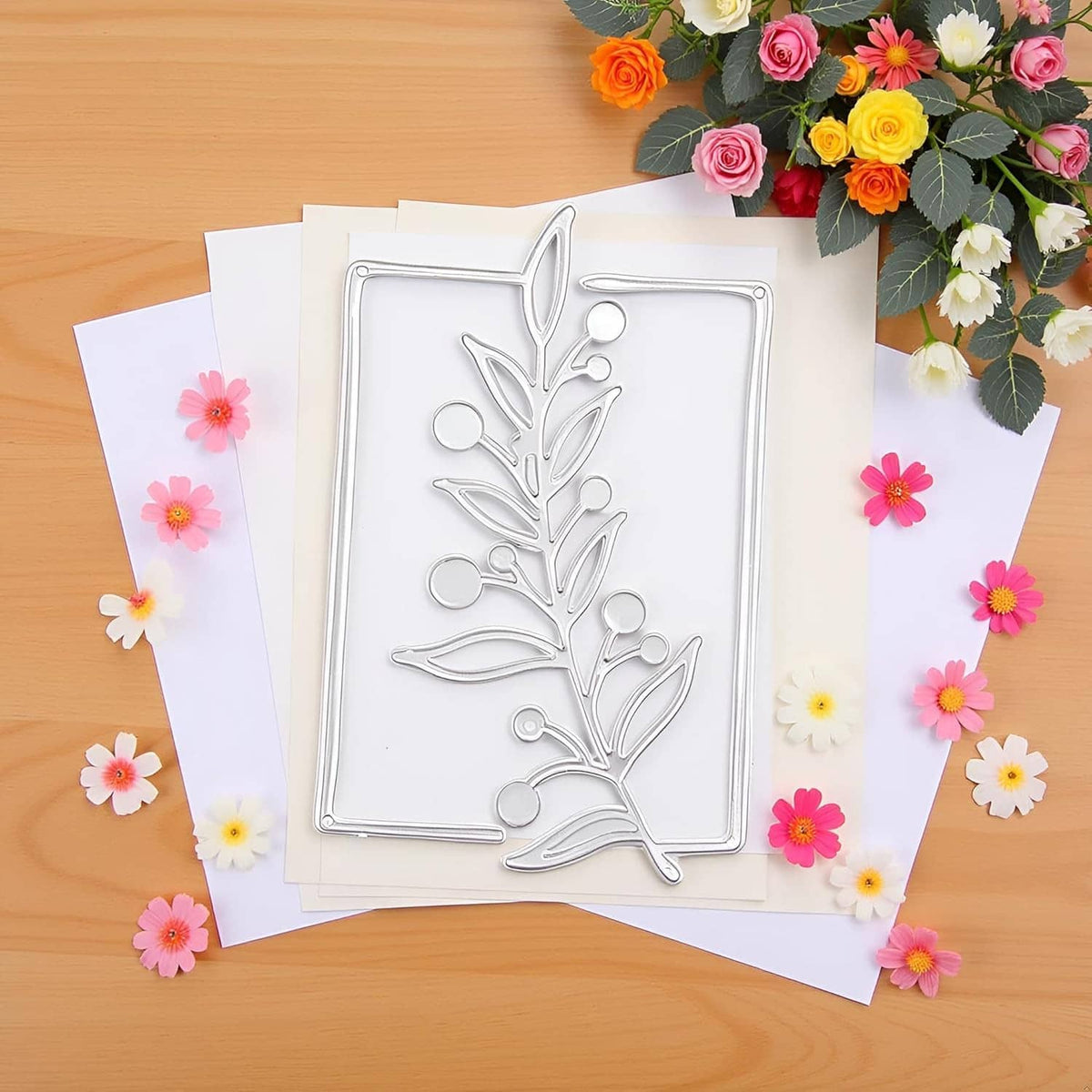 Floral tree branch metal cutting die on a card surrounded by flower cutouts