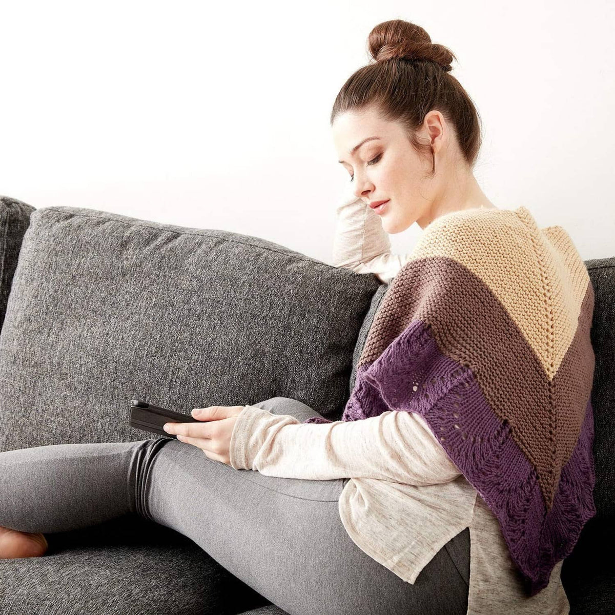 Draped triangular knit shawl, tan center with dark purple and brown stripes.