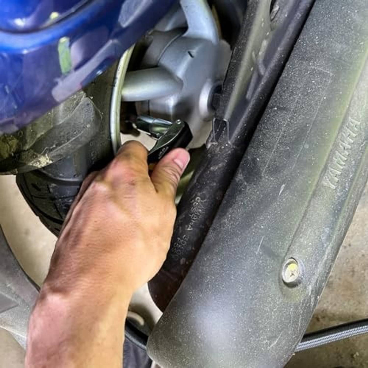 90-degree air chuck attaching to tire valve; metal tip and black handle