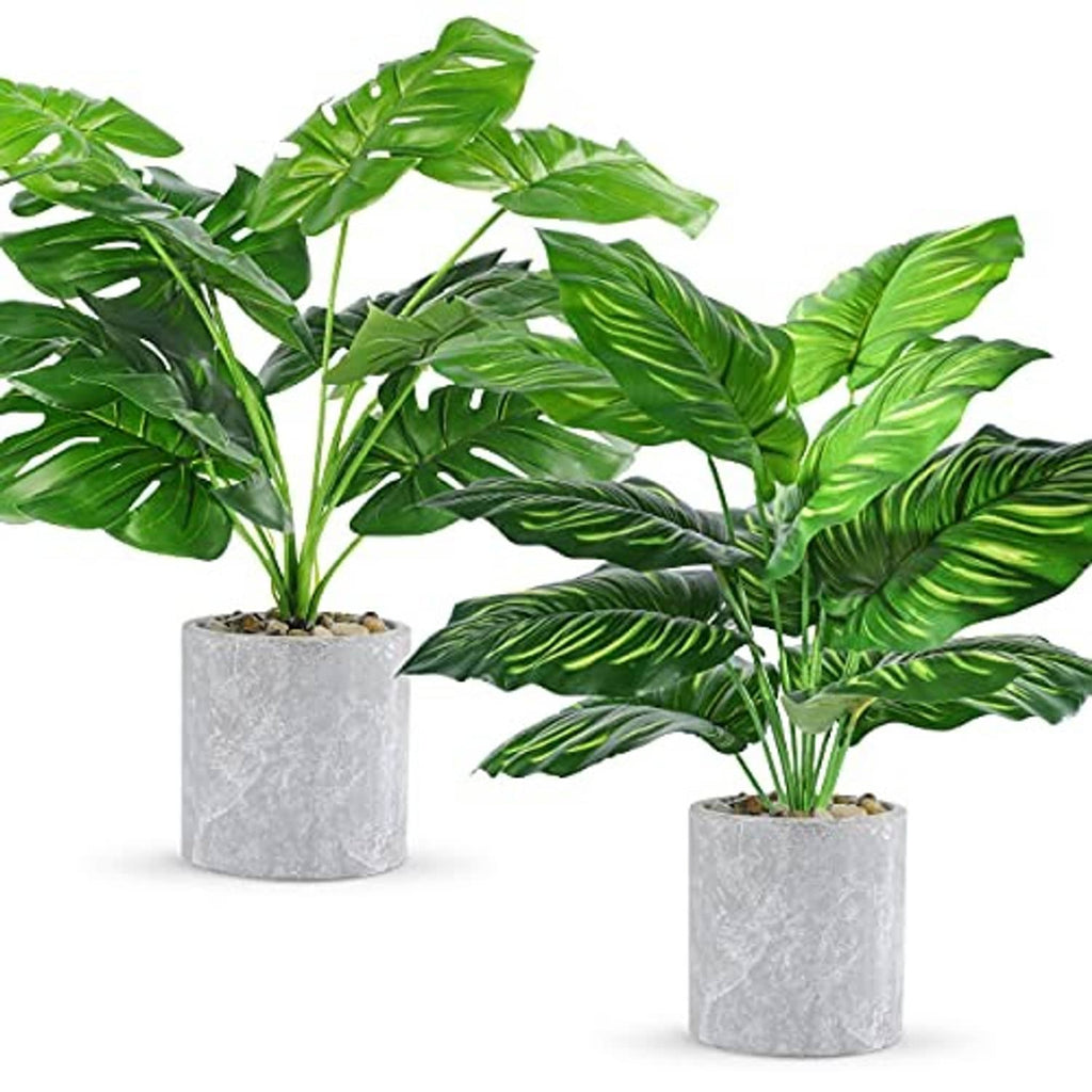 Artificial tropical fake plant set with green leaves in gray stone-texture pots