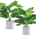 Artificial tropical fake plant set with green leaves in gray stone-texture pots
