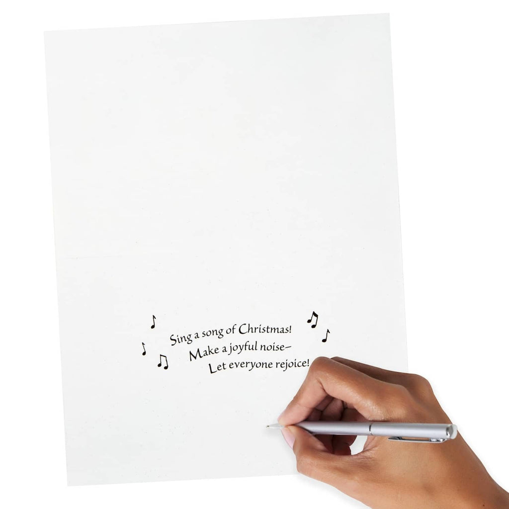 White greeting card inside panel with printed Christmas verse and a writing hand
