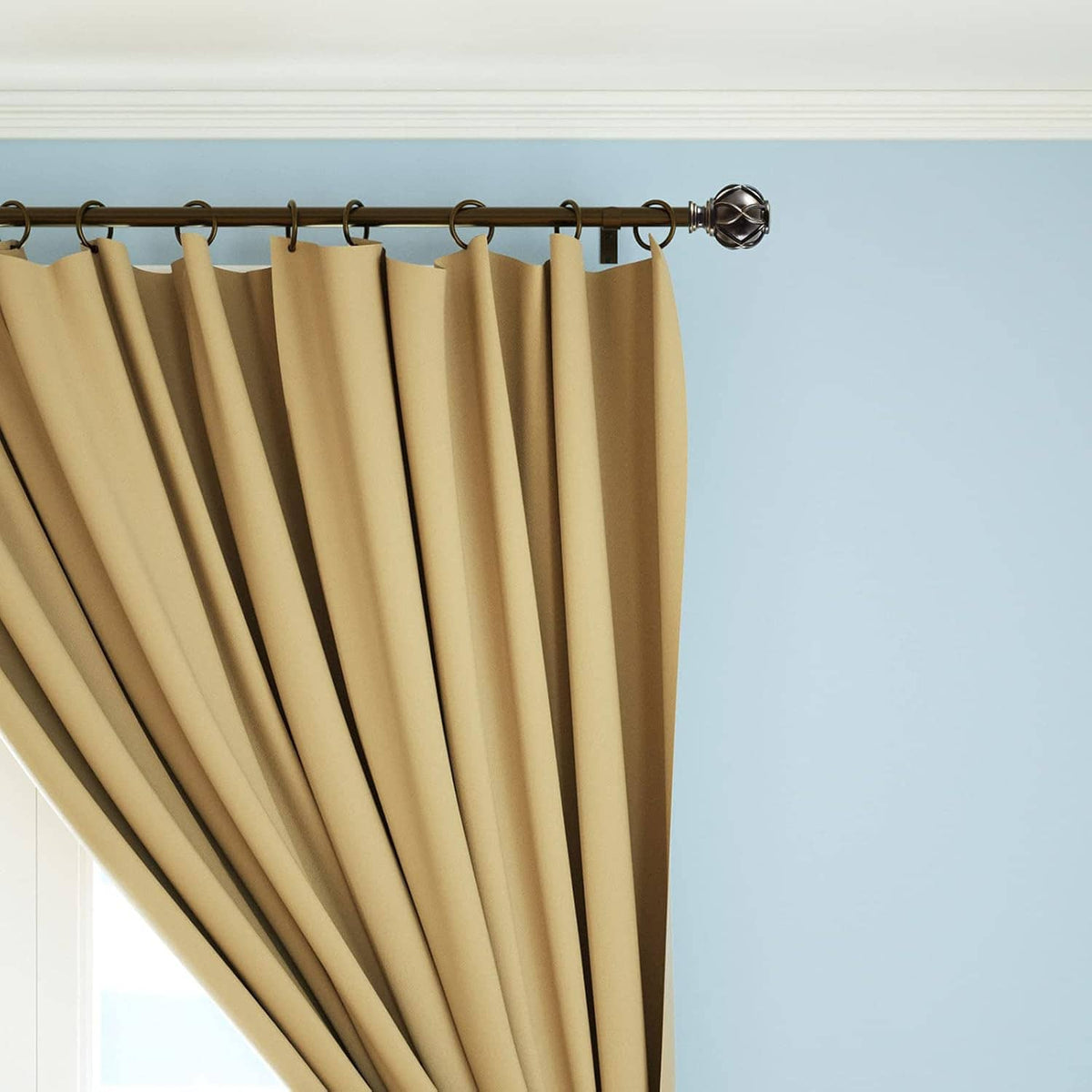 Gold-toned curtain rod finials with sculpted diamond pattern along the rod