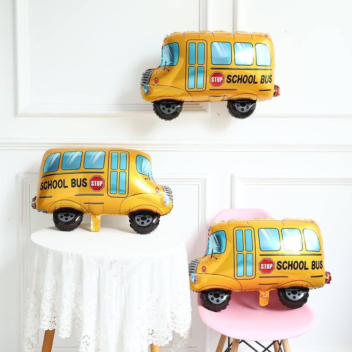 Three school bus balloons, yellow buses with blue windows and stop signs