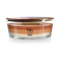 Glass jar candle with amber-orange wax and WoodWick logo label