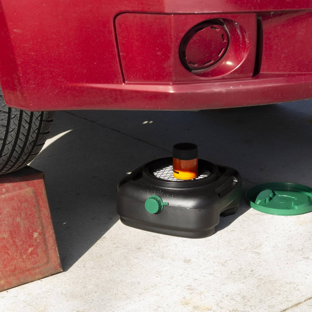 Black oil drain pan with green lid and green drain spout