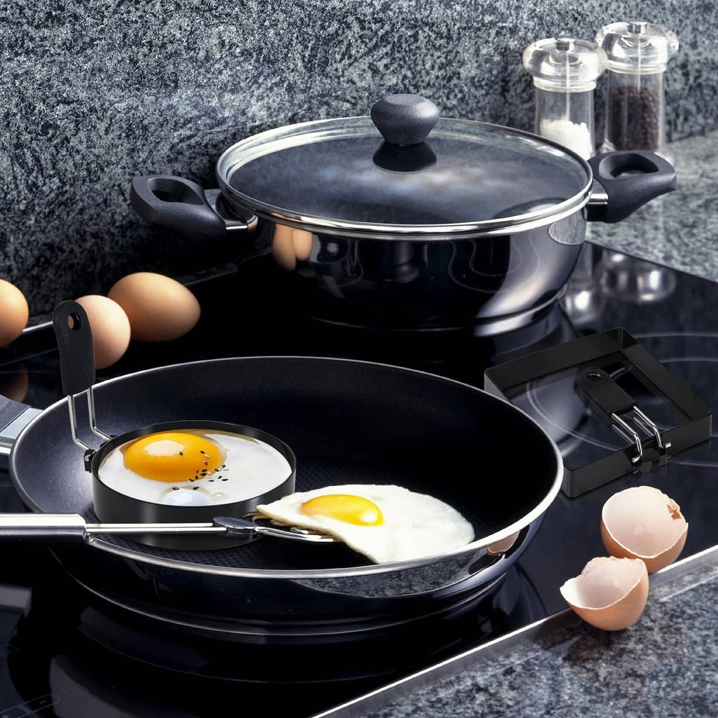 Black egg rings in a frying pan, round and square molds with two sunny-side eggs