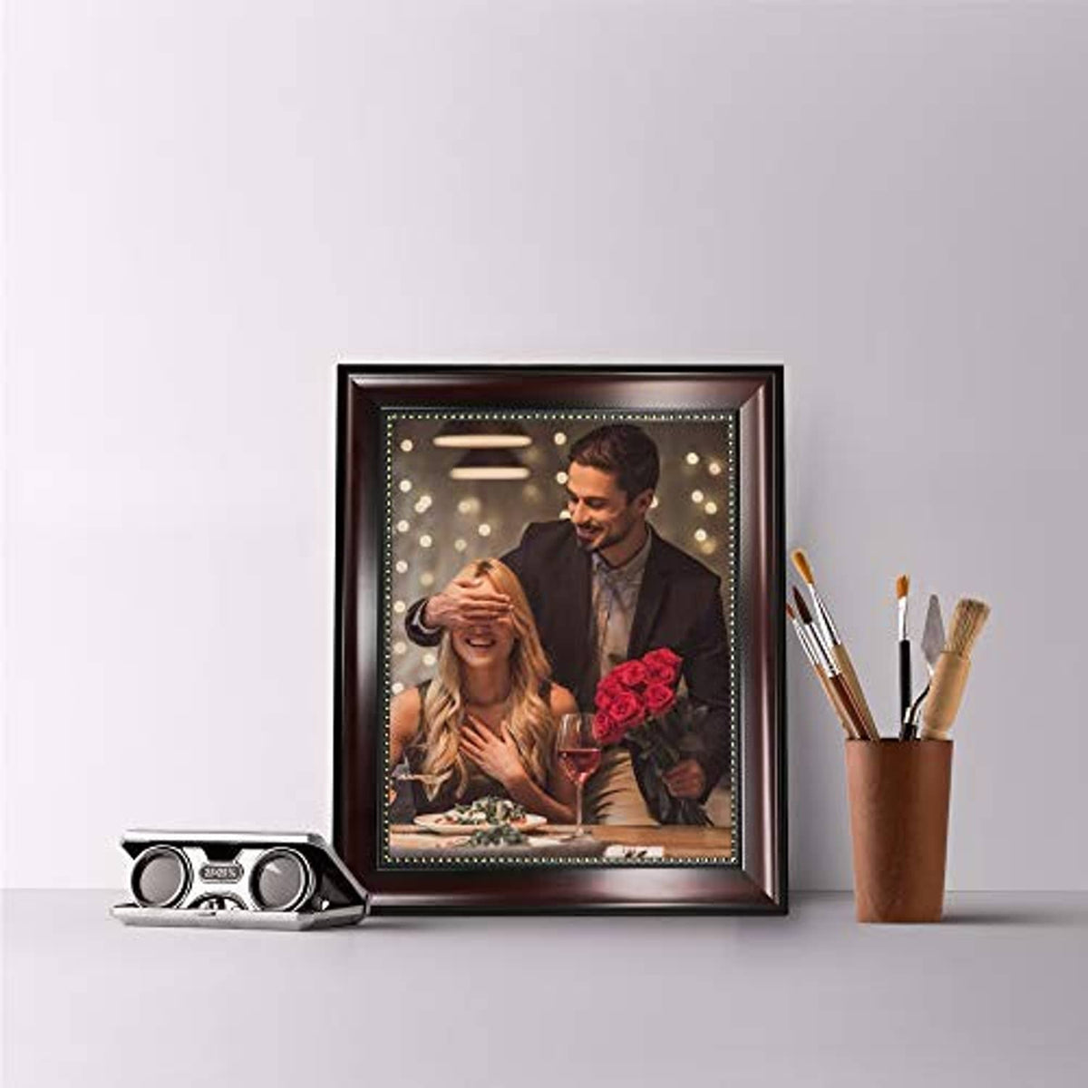 Brown wooden tabletop photo frame with glowing border featuring a couple and red roses
