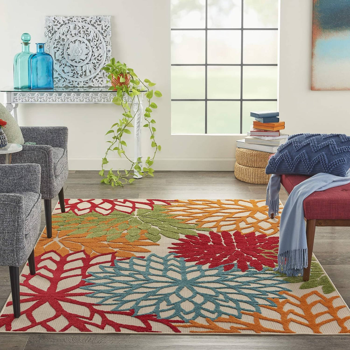 Tropical area rug with large floral motifs in red, teal, orange, and green