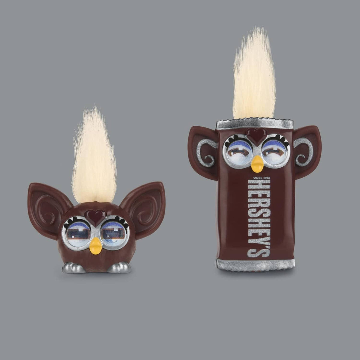 Two small chocolate-themed Furby minis with white mohawks and goggles