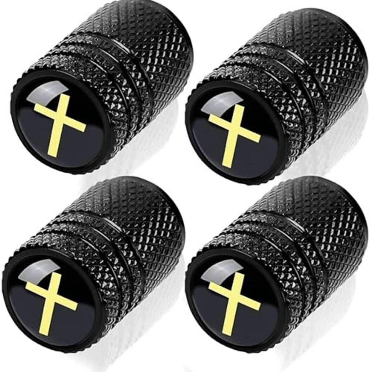 Four black textured tire valve stem caps with yellow cross emblem