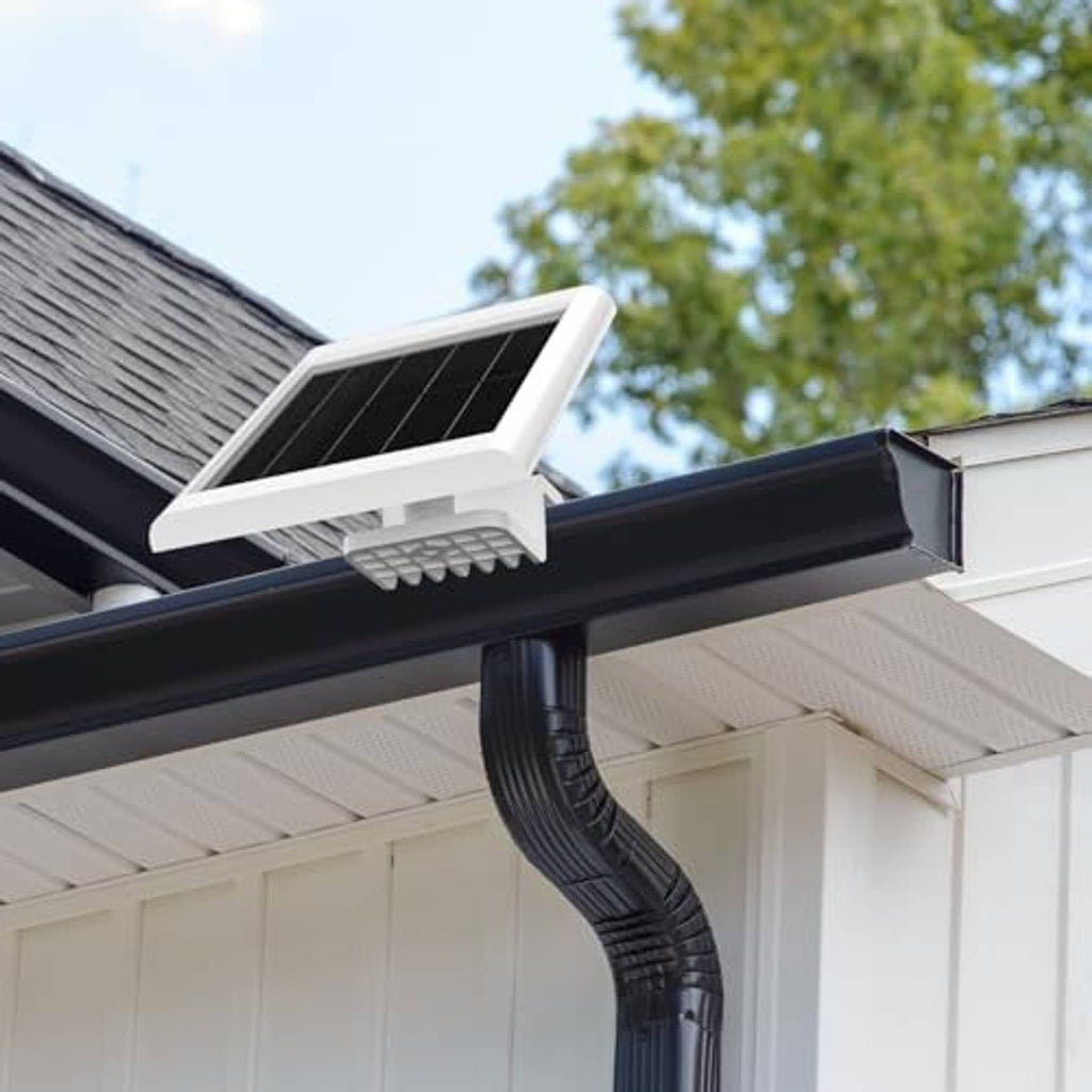 Installed white adjustable gutter mount with solar panel on a house eave