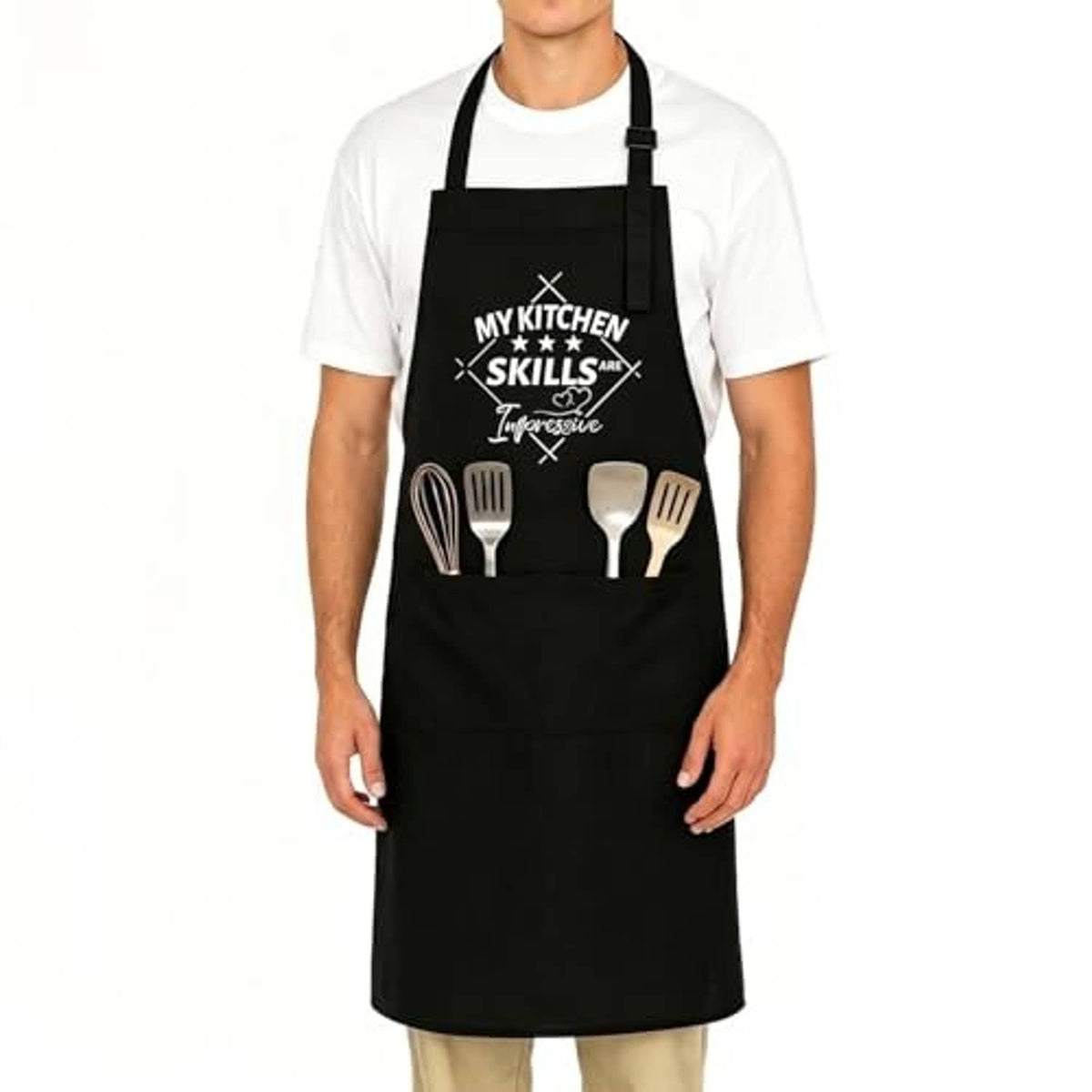 Black cooking apron on model, adjustable neck straps, front kitchen skills utensils print