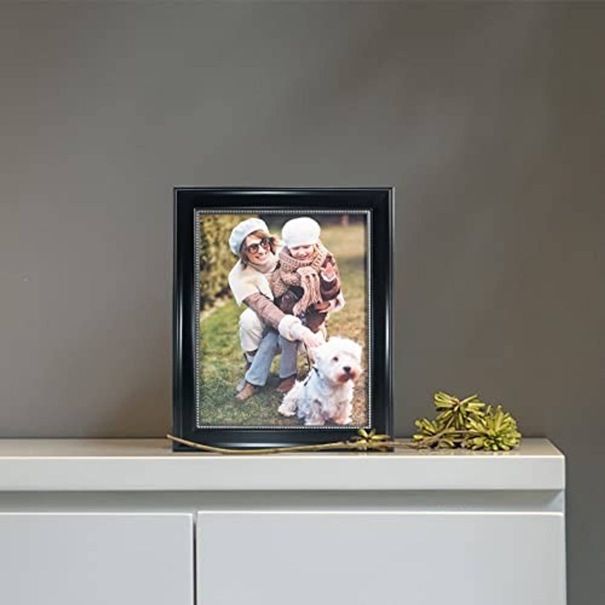 Black 8x10 picture frame standing on a shelf with silver-bead border and real glass