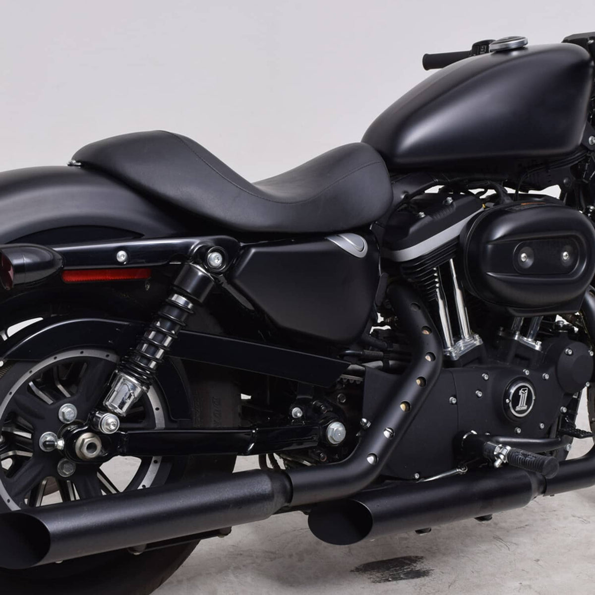 Black solo motorcycle seat with contoured cushion and stitched seam, mounted on a bike