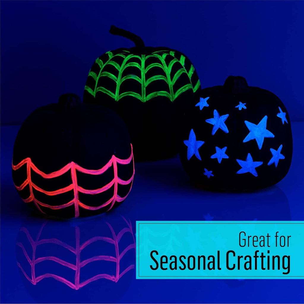Glowing neon acrylic paint designs on seasonal pumpkin craft shapes