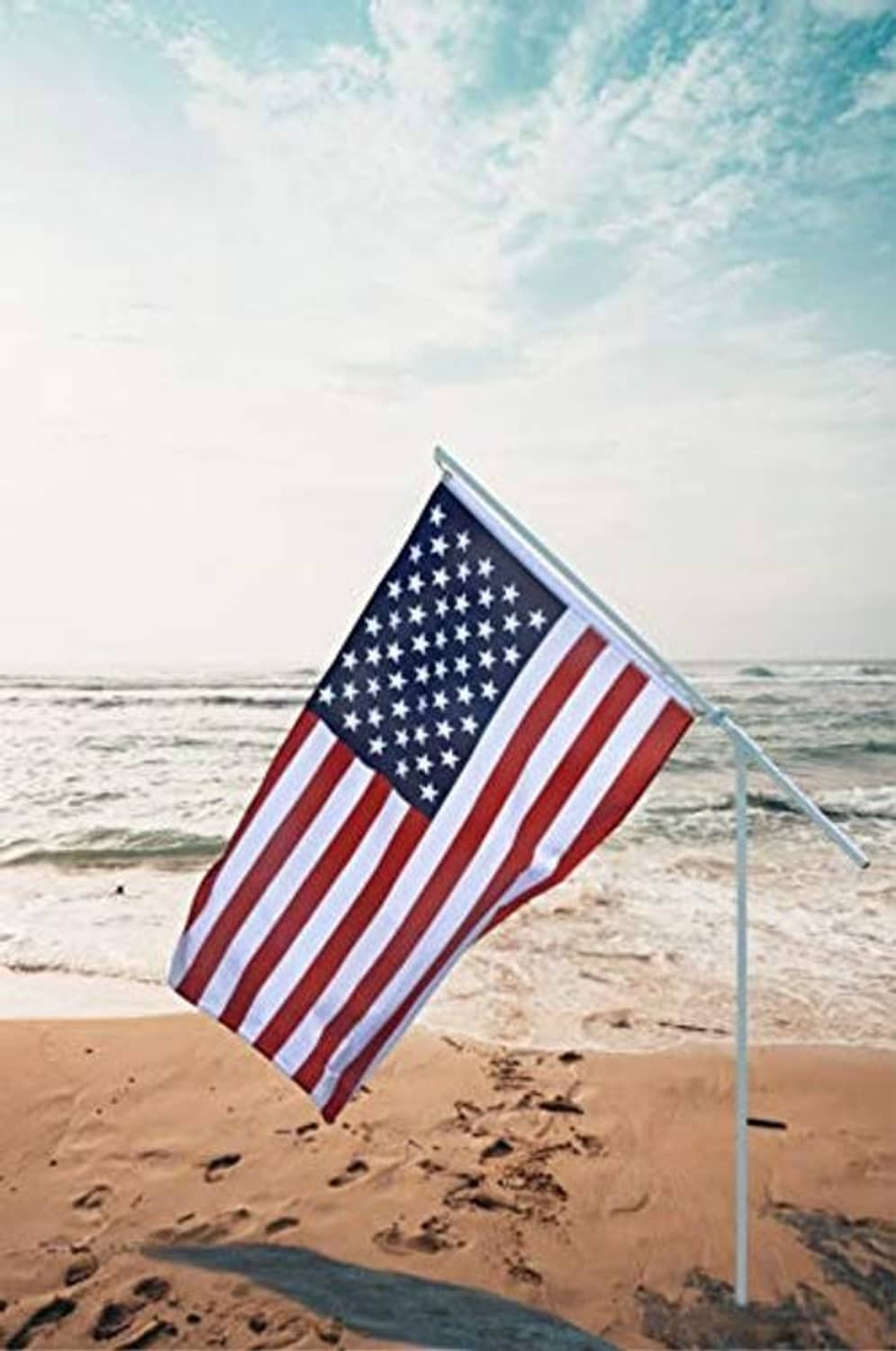 Portable flagpole with U.S. flag and ground stake on the beach