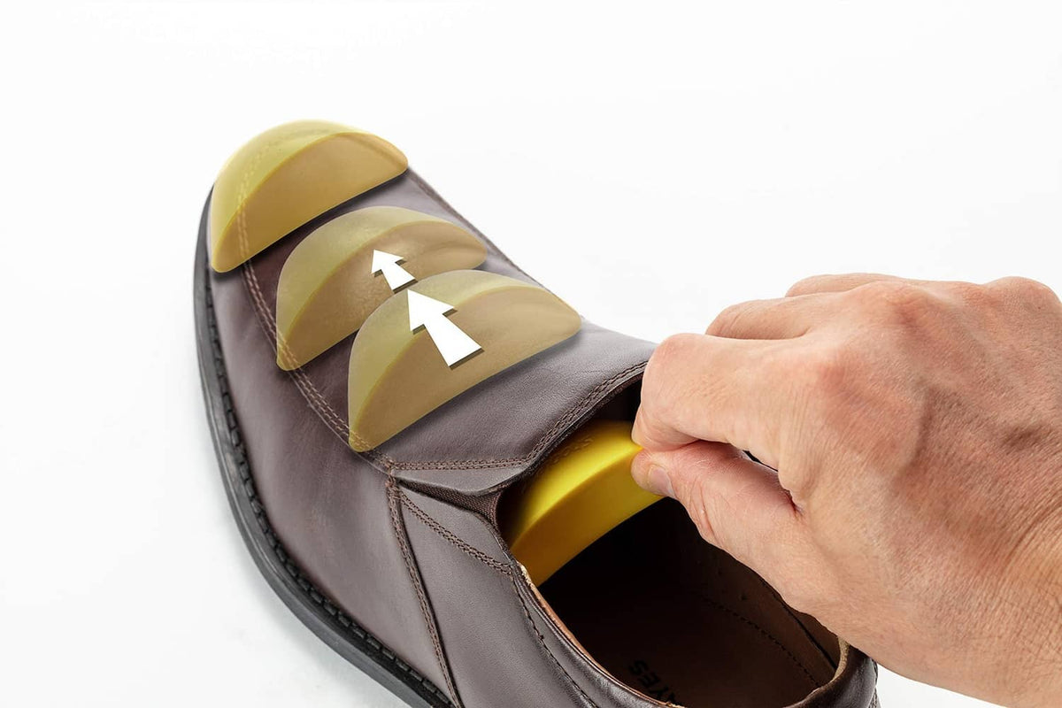 Yellow shoe filler insert being placed into a shoe to fill extra space