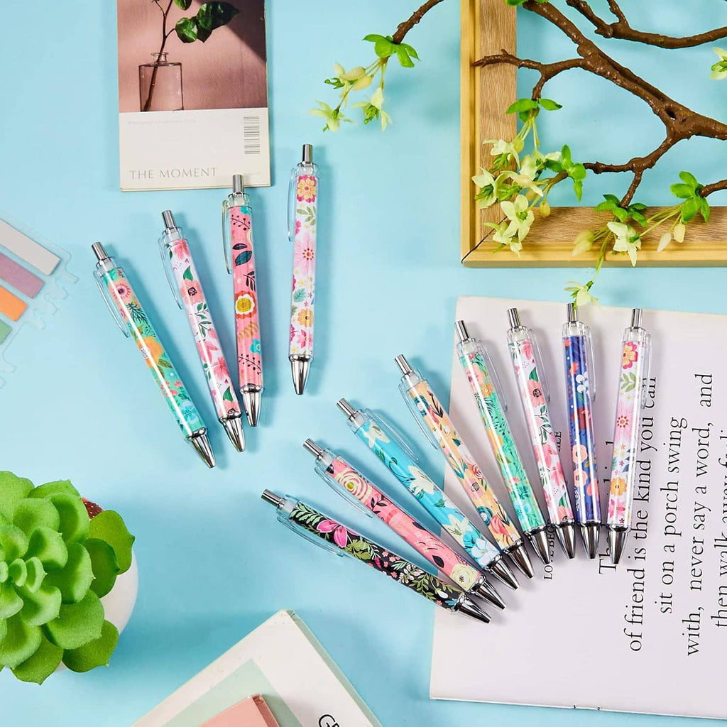 Group of floral ballpoint pens with silver tips laid out on a desk