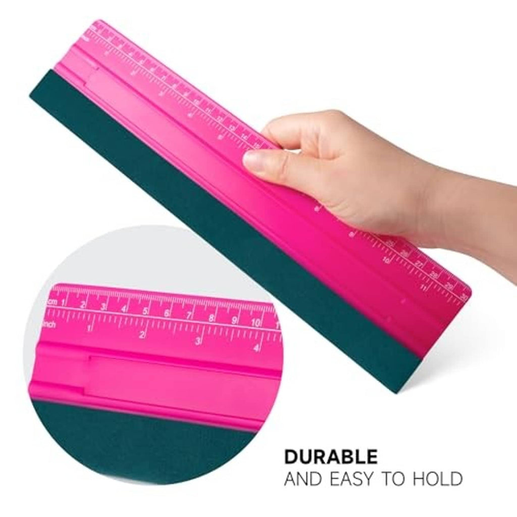 Pink vinyl squeegee with dark green felt edge, held by hand at an angle