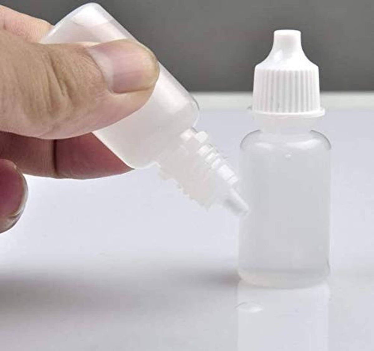 White empty plastic dropper bottle with ribbed cap and eyedropper tip