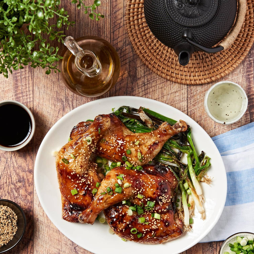 Partial Lee Kum Kee dark soy sauce bottle beside chicken dish with scallions