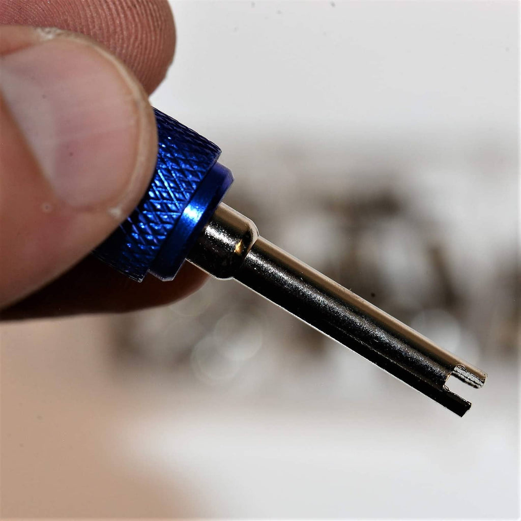 Close-up of blue-handled A/C core tool with metal valve core tip.