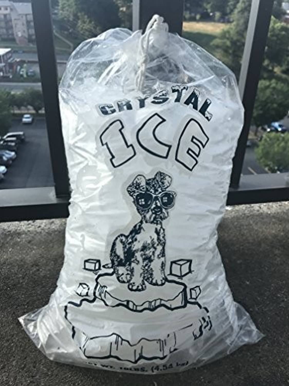 Clear plastic ice bag with CRYSTAL ICE graphic, cotton drawstring tied at top