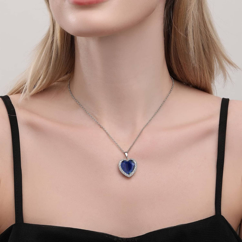 Blue heart pendant necklace with crystal border on silver chain, worn
