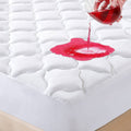 White quilted waterproof queen mattress protector with water droplet on surface