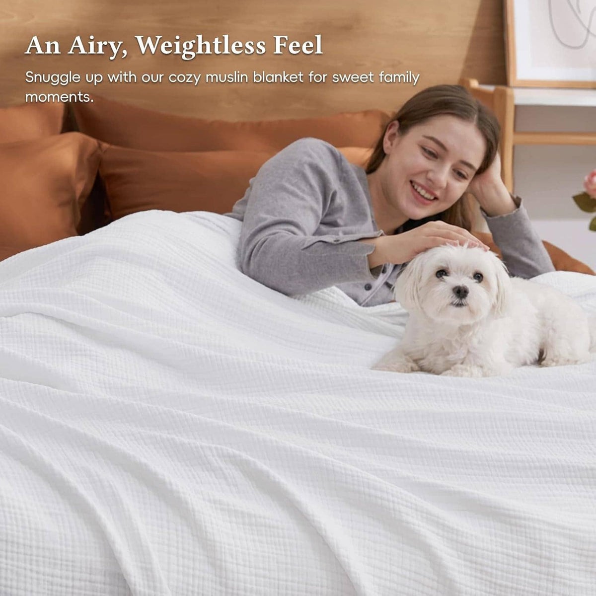 White muslin cotton blanket on a bedspread with a woman and small dog