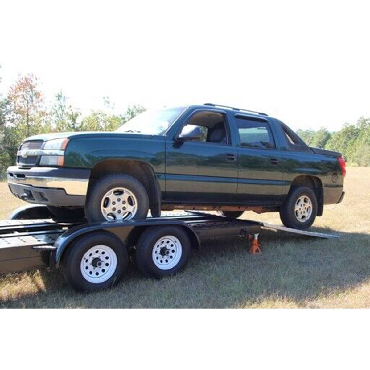 Aluminum trailer ramps pair with wheel channels on ground for vehicle loading