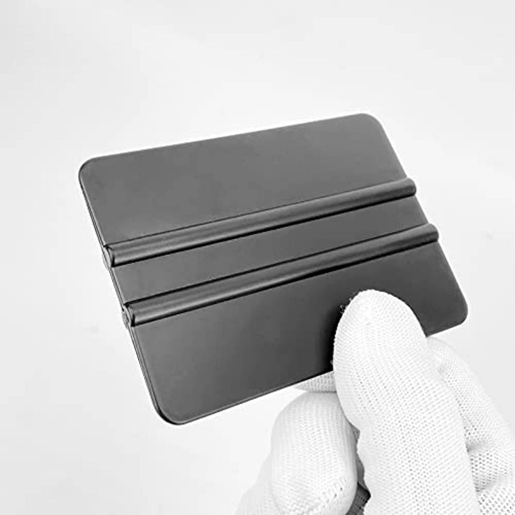 Close-up of a black rectangular vinyl squeegee scraper with ribbed plastic edge.