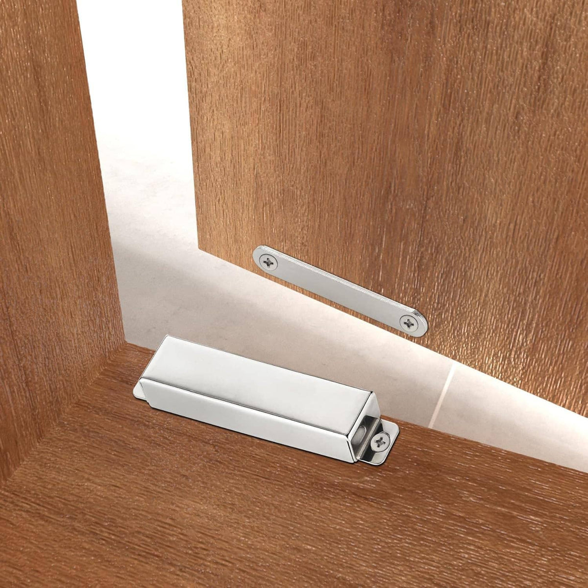 Stainless steel magnetic door catch with strike plate mounted across a door gap