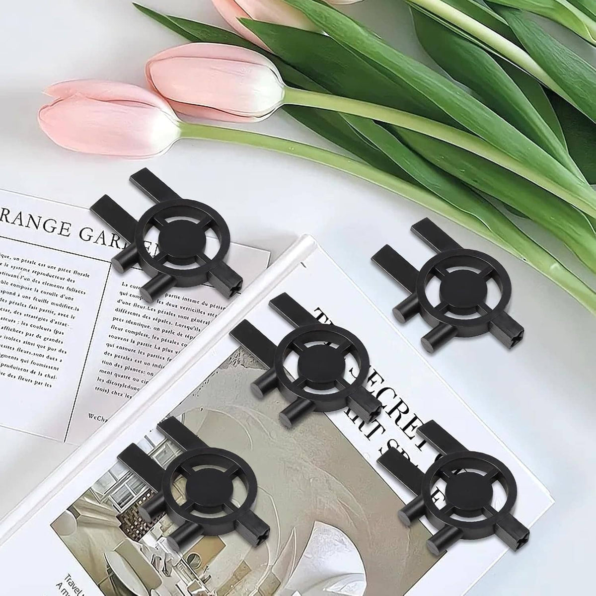 Set of five black plastic dispenser keys with circular rings and prongs